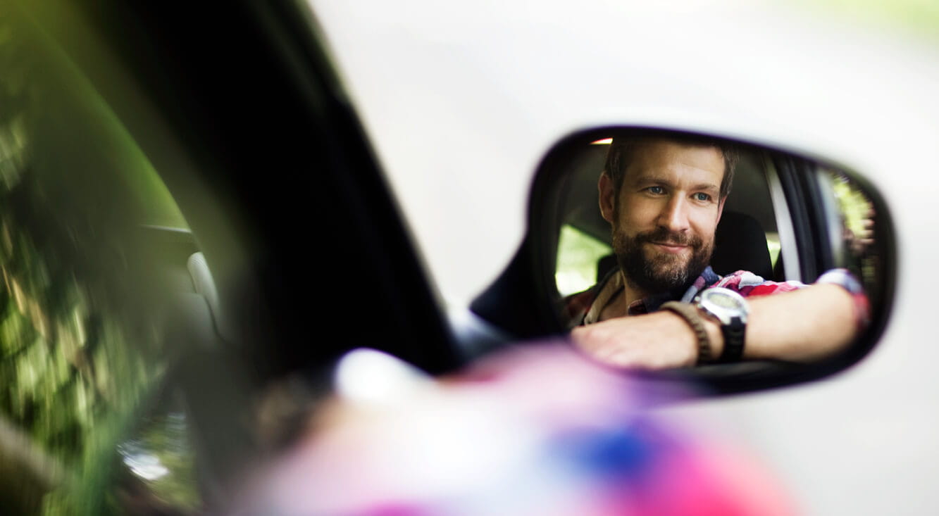 Container Inspection - Young man reflected in a car side mirror
